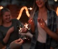 Sparkle up your life. a group of cheerful young friends having fun with sparklers together outside at night. Royalty Free Stock Photo