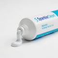 Sparkleclean toothpaste tube dispensing white paste Royalty Free Stock Photo