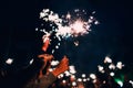 Sparkler in hands of happy people on holiday with sparks Royalty Free Stock Photo