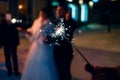 Sparkler with sparks in the hand of man on holiday on blurry background Royalty Free Stock Photo