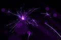 Sparkler in violet and white light on a black background Royalty Free Stock Photo