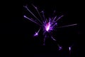 Sparkler in violet and white light on a black background Royalty Free Stock Photo