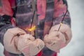 Sparklers burning in children`s hands in winter mittens Royalty Free Stock Photo