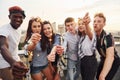 With sparklers in hands. Group of young people in casual clothes have a party at rooftop together at daytime Royalty Free Stock Photo