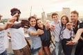 With sparklers in hands. Group of young people in casual clothes have a party at rooftop together at daytime Royalty Free Stock Photo