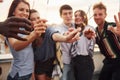 With sparklers in hands. Group of young people in casual clothes have a party at rooftop together at daytime Royalty Free Stock Photo