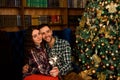 Young beautiful kisser and burning sparklers. Loving couple in Christmas decorated room.