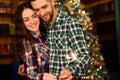 Young beautiful kisser and burning sparklers. Loving couple in Christmas decorated room.