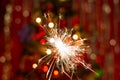 Sparklers near the Christmas tree with a red background Royalty Free Stock Photo