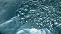 Sparkling aqua bubbling inside container closeup. Soda fizzy drink glass macro