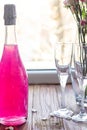 Sparkling brilliant raspberry drink. Champagne in two glasses stands on a wooden table with ice. For flowers and a garland Royalty Free Stock Photo