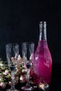 Sparkling brilliant raspberry drink. Champagne in two glasses stands on a wooden table with ice. For flowers and a garland Royalty Free Stock Photo