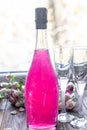 Sparkling brilliant raspberry drink. Champagne in two glasses stands on a wooden table with ice. For flowers and a garland Royalty Free Stock Photo