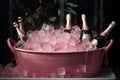 Sparkling champagne bottles chilling in a pink bucket filled with ice cubes, set against a dark backdrop with red berries.