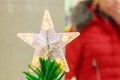 Sparkling Christmas tree toy five-pointed Russian star on top of artificial Christmas tree Royalty Free Stock Photo