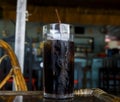 Sparkling drink with ice in glass. Cool beverage in hot summer day. Coke in glass with straw