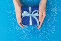 Sparkling Gift box wrapped in craft paper and tied with bow in Kid`s hands