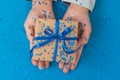 Sparkling Gift box wrapped in craft paper and tied with bow in Kid`s hands