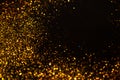 Sparkling gold glitter on a black background, magic abstract background. Round frame made of gold particles,