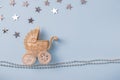 Sparkling golden and silver baby carriage with stars on blue background and christmas decor. Greeting card. Overhead flatlay with
