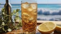 sparkling golden vodka drink with ice and lemon on the beach while enjoying the crashing waves on a sunny day Royalty Free Stock Photo