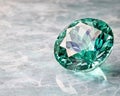 Sparkling green gemstone on a reflective surface