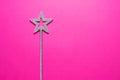 Sparkling magic wand on a pink background. Concept of celebration and magic, copy space. Royalty Free Stock Photo