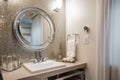 sparkling mirror hanging on the wall of luxurious bathroom, with silver fixtures and towels