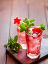 Sparkling pink strawberry lemonade on dark wooden background