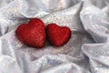 Sparkling red hearts on shiny rainbow fabric.