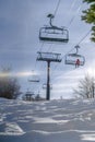 Sparkling sunlit snow under chair lifts and sky