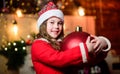 Sparkling toy. Festive atmosphere christmas day. Girl santa claus costume hold big ball christmas tree ornaments Royalty Free Stock Photo