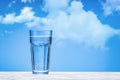 Sparkling water in large glass cup on white wooden surface.