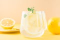 Sparkling water with lemon, melissa and ice in glasses and lemon slices on a saucer on a yellow background. Alcoholic drink Royalty Free Stock Photo