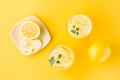 Sparkling water with lemon, melissa and ice in glasses and lemon slices on a saucer on a yellow background. Alcoholic drink Royalty Free Stock Photo