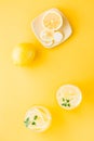 Sparkling water with lemon, melissa and ice in glasses and lemon slices on a saucer on a yellow background. Alcoholic drink Royalty Free Stock Photo