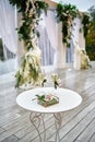 Sparkling wedding glasses with champagne, wedding rings and wedding arch in blur on background outdoors, copy space Royalty Free Stock Photo