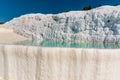 The sparkling white terraces of shallow limestone pools filled with azure blue water at Pamukkale, Turkey