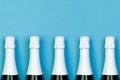 Sparkling wine bottle in row on blue background. Holidays, party and celebrations concept Royalty Free Stock Photo