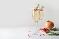 Sparkling wine, pomegranate, rosemary sprig on white table. Xmas drink Royalty Free Stock Photo