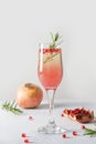 Sparkling wine, pomegranate, rosemary sprig on white table. Xmas drink Royalty Free Stock Photo