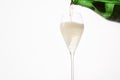 Sparkling wine pours from green bottleneck, creates bubbles.