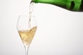 Sparkling wine pours from green bottleneck, creates bubbles.