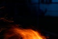 Sparks and flame erupt from the top of a chimney starter fire on a backyard grill