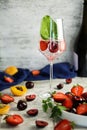 Sparlking wine with berries. Refreshing cooling sparkling summer drink with fresh strawberry, cherry and ice cubes. Prosecco Royalty Free Stock Photo