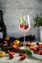 Sparlking wine with berries. Refreshing cooling sparkling summer drink with fresh strawberry, cherry and ice cubes. Prosecco Royalty Free Stock Photo