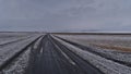 Sparse landscape with view of snow-covered ring road (route 1) in southern Iceland near Skaftafell on cloudy winter day. Royalty Free Stock Photo