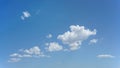 Sparse puffy clouds and blue sky for background use or sky substitution