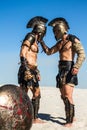 Spartan warrior holding a Roman for his helmet