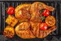 A spatchcocked grilled chicken with charred corn and roasted cherry tomatoes on a cast iron grill pan Royalty Free Stock Photo